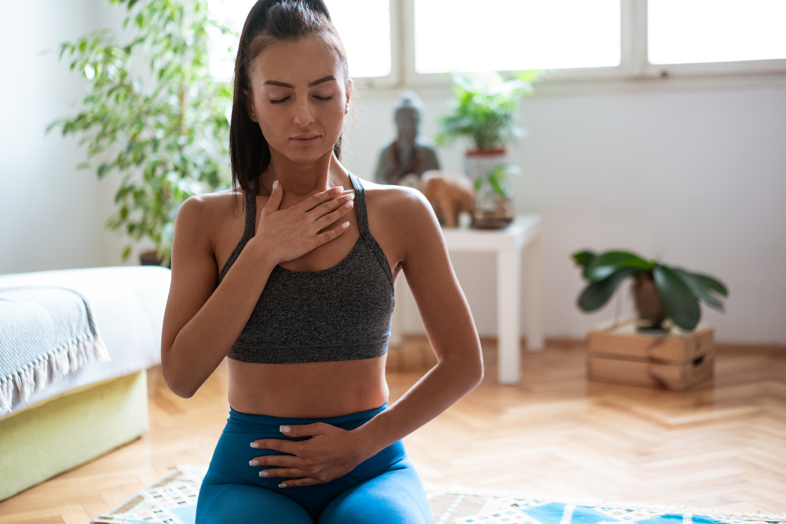 Young woman practicing  breathing exercise at home